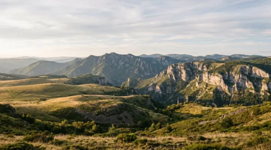 Vue panoramique des différentes micro-régions de Lozère : plateaux de l'Aubrac, causses calcaires et vallées cévenoles sous un ciel lumineux