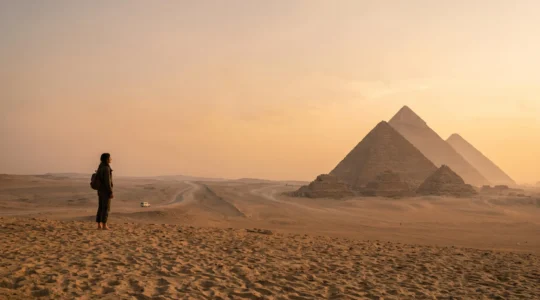 Voyageur contemplant les pyramides de Gizeh au lever du soleil dans une ambiance sereine et sécurisée